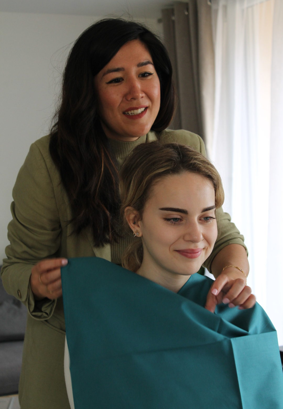 Coaching en image à Nice – Révélation des couleurs par drapping dans un atelier de visagisme Atelier de visagisme à Nice – Cliente souriante face au miroir pendant une séance de drapping en coaching en image