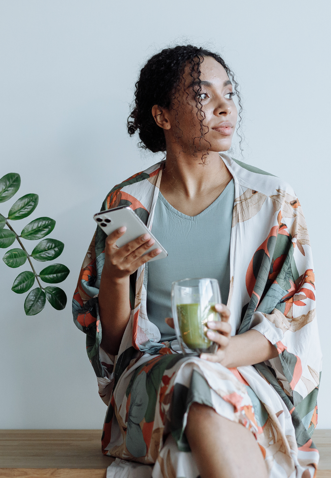 Déconnecter pour mieux se retrouver : l’appel du bien-être à Nice Femme avec un téléphone à la main et un matcha, le regard pensif, illustrant le besoin de déconnexion et de reconnexion intérieure à Nice.